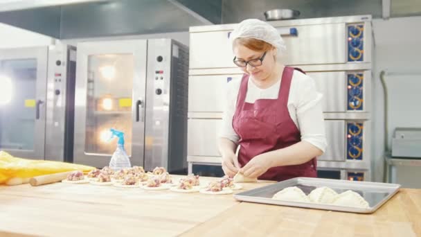 Volwassen soort lachende vrouw bakt en de vorming van de taarten in de bakkerij — Stockvideo