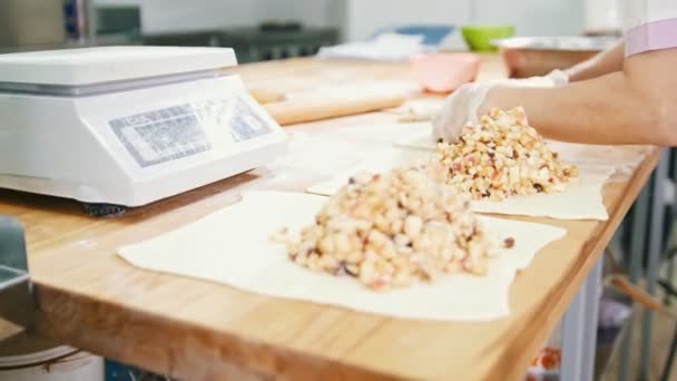 Mujer adulta hornea y forma tartas de manzana en la panadería — Vídeos de Stock