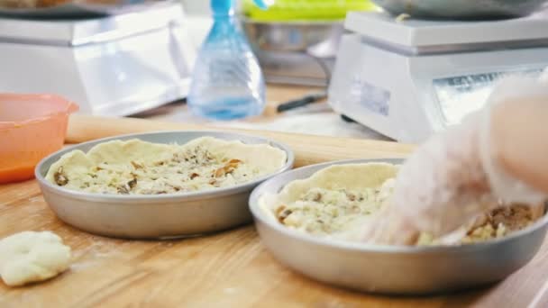 Las empleadas se llenan con un relleno de pasteles de carne en la panadería — Vídeos de Stock