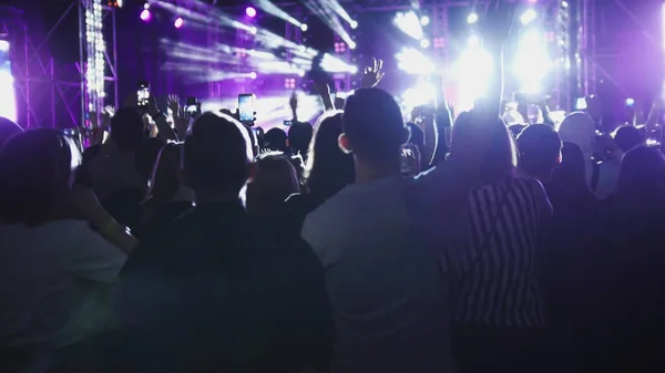 Jongeren opheffen van handen met smartphones bij de rep rockconcert — Stockfoto