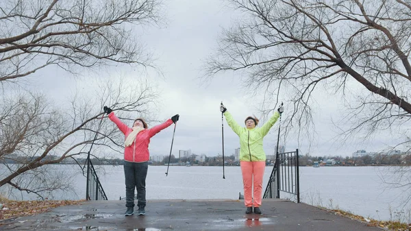 Senior vrouwen in herfst park hebben opleiding - opwarmen voordat nordic-walking — Stockfoto