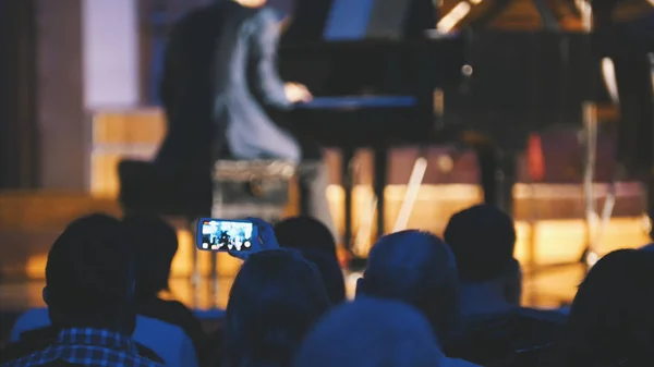 クラシック音楽 - スマート フォン、スコットランドのミュージシャンのパフォーマンスを撮影する人々 のコンサートでの観客 — ストック写真