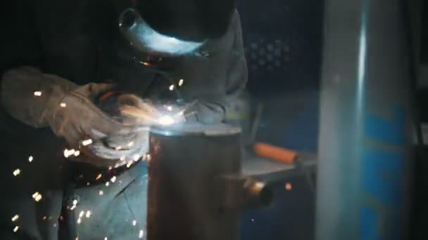 De lasser lasnaden metalen onderdelen in de fabriek — Stockvideo