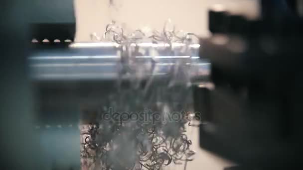 Corte de piezas metálicas en la máquina de torno en la fábrica, muchas virutas metálicas, concepto industrial, vista de perfil — Vídeo de stock