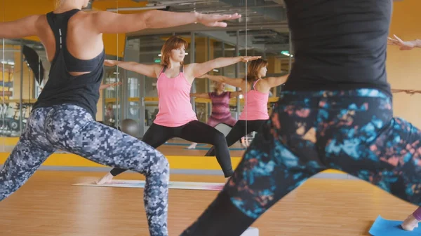 Mujer deportiva muestra ejercicios de yoga para mujeres en el gimnasio — Foto de Stock