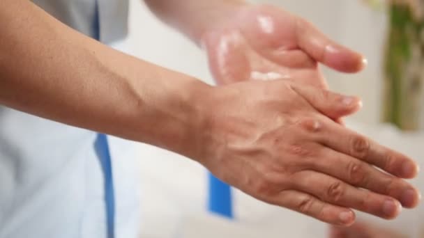 Человек соктор наносит крем на руку перед медицинской процедурой — стоковое видео