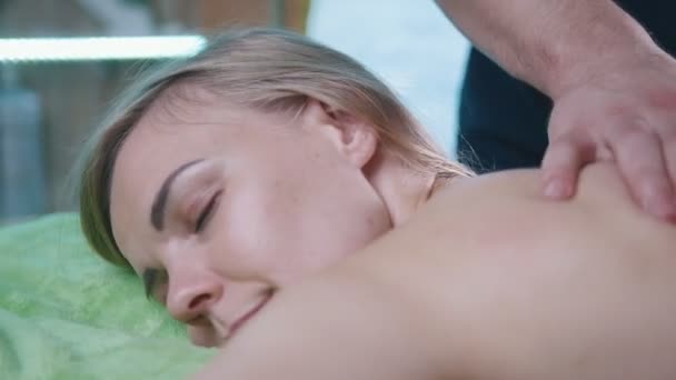 Masaje de relajación para espalda. Hombre rabioso masaje para joven rubia femenina — Vídeos de Stock