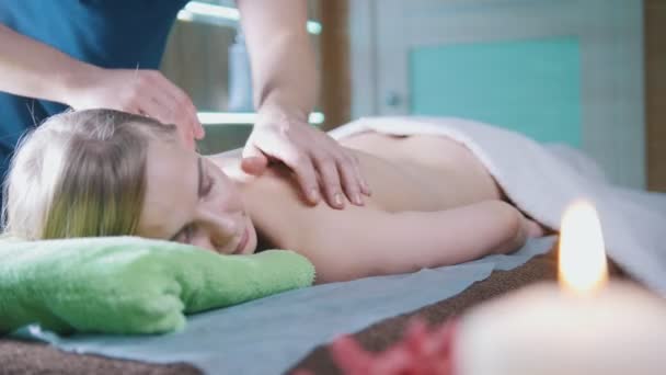 Mans mãos na parte de trás da menina no salão de massagem — Vídeo de Stock
