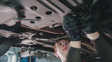 Araba Servis Atölyesi - tamirci arabanın alt aracın altına detayını unscrews.