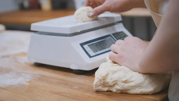 Пекарь взвешивает тесто для выпечки — стоковое фото