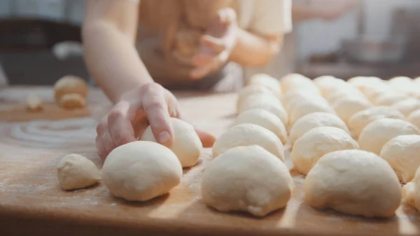 Kuchaři roll těsto na pečení, kousky syrového těsta na dřevěné desce — Stock fotografie