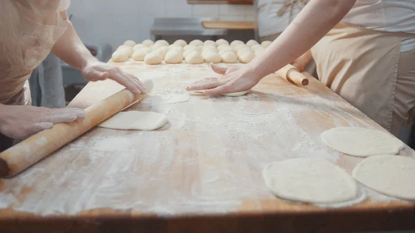 Cooks roll the dough for baking, raw dough on the Board