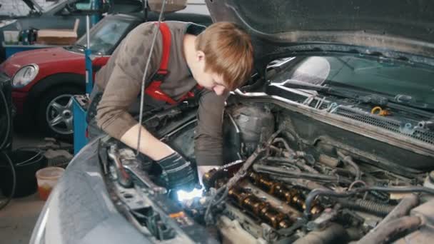 Mecánico con reparación de lámparas motor automotriz, reparación de automóviles, trabajo en el taller — Vídeo de stock