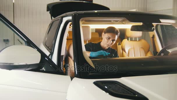 Детализация автомобиля - женщина чистит приборную панель в роскошном автомобиле — стоковое видео