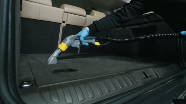 Člověk čistí vnitřek vozu s vysavač, mokré čištění kufru — Stock video