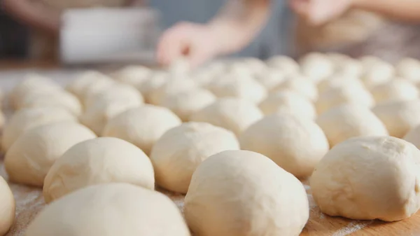 Повар делает мясные пироги руками в пекарне — стоковое фото