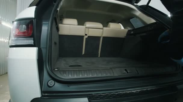 Man cleans the car interior with vacuum cleaner, dry cleaning of trunk — Stock Video