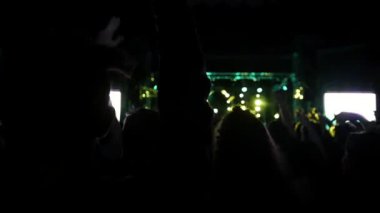 Rock konserinde büyük bir kalabalık. Seyirciler arasında Sahne Alanı'nın parlayan ışıklar.