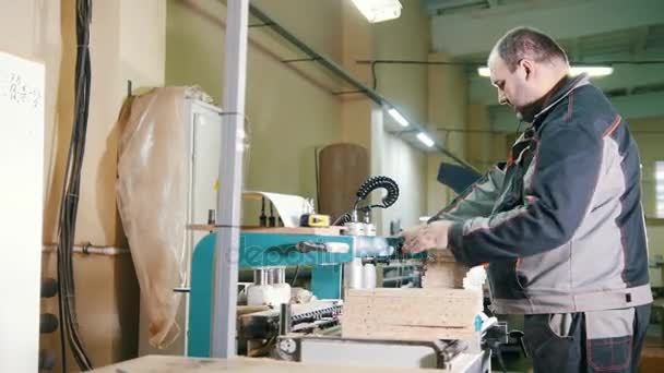 Carpenter cut a wooden workpiece on a furniture factory — Stock Video