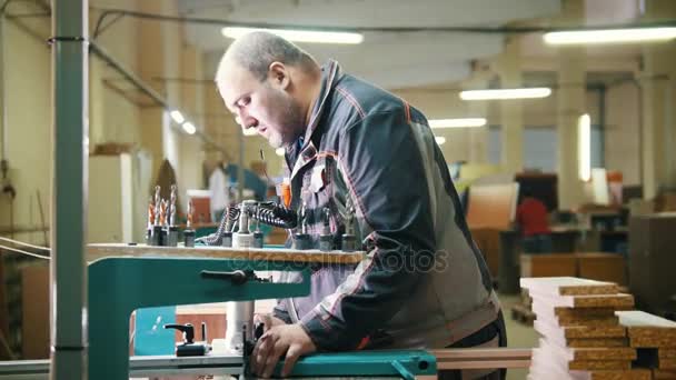 Trabajador carpintero cortar un fragmento de madera en una fábrica de muebles — Vídeo de stock