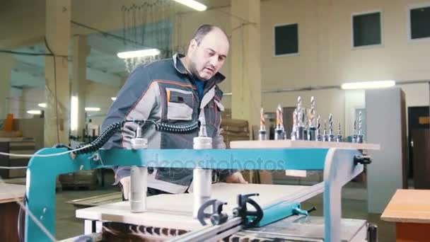 Carpenter handles a wooden fragment on a furniture factory — Stock Video