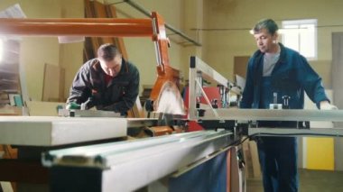 İşçiler marangoz ahşap detay mobilya Fabrikası'nda elektrikli testere kesim