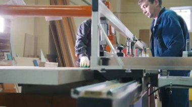 İşçiler ahşap detay mobilya Fabrikası'nda elektrikli testere kesim