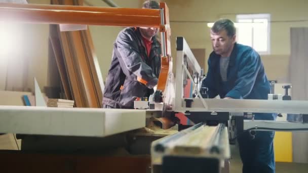 I lavoratori stanno tagliando il frammento di legno sulla sega elettrica alla fabbrica di mobili — Video Stock