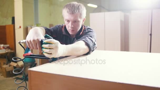 Carpinteiro trabalhando com um grampeador industrial elétrico na fábrica, fixação de peças de mobiliário — Vídeo de Stock