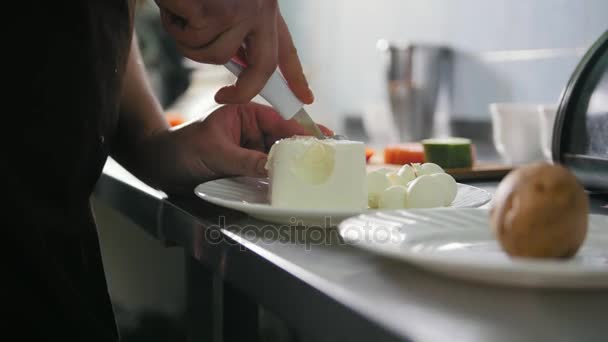 Шеф режет сыр на коммерческой кухне. — стоковое видео