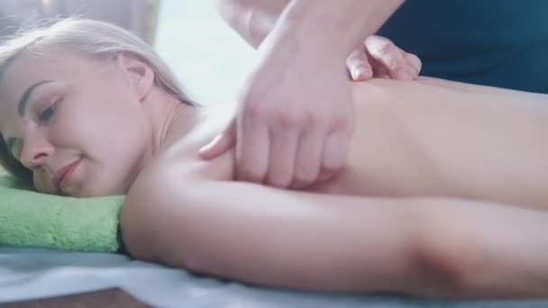 Mans mani sul retro della ragazza in sala massaggi — Video Stock