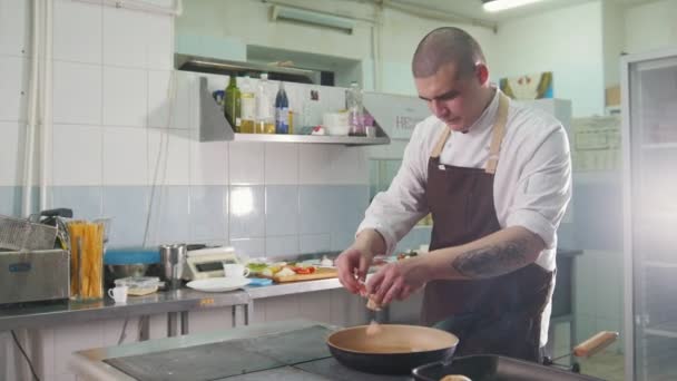 Кухар смажить бекон на сковороді в ресторані — стокове відео