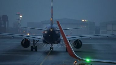 Alacakaranlıkta havaalanında jet uçağın arka görünüm