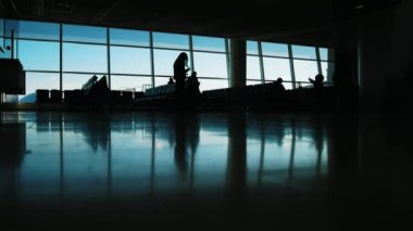 Yolcular içinde hava Havaalanı terminali - anne ile küçük çocuk silüeti