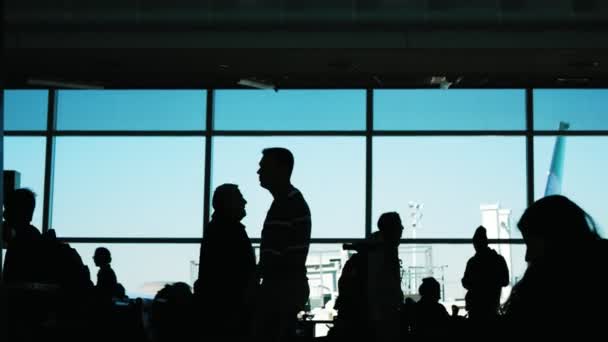 Farklı yolcu siluet kalkış için bekleyen Havaalanı Terminal — Stok video