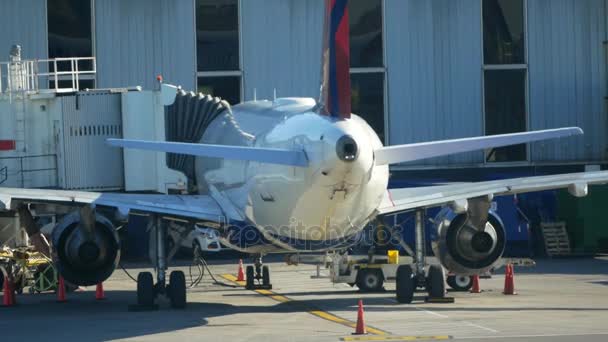 Fuselage d'un aéronef de passagers dont le moteur tourne à l'aéroport — Video