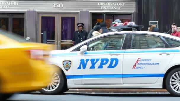 НЬЮ-ЙОРК, США - ДЕКАБРЬ, 2017 г.: полицейская машина Нью-Йорка стоит на Манхэттене возле Эмпайр-Стейт-Билдинг — стоковое видео
