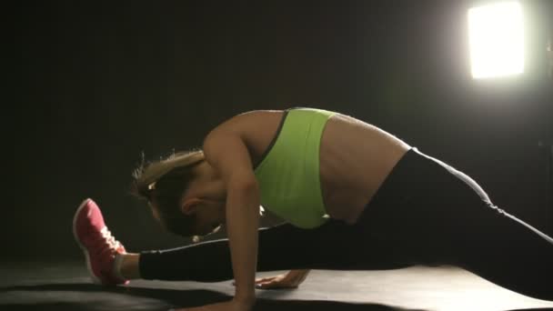 Młoda atrakcyjna kobieta w studio wyciąganie nóg i brzucha — Wideo stockowe