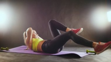 Genç fitness modeli eğitim elbiseli egzersiz için bacaklar ve karın Studio