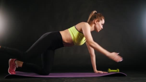 junge blonde Fitness-Model im Trainingsanzug machen Übung für Bauch im Studio
