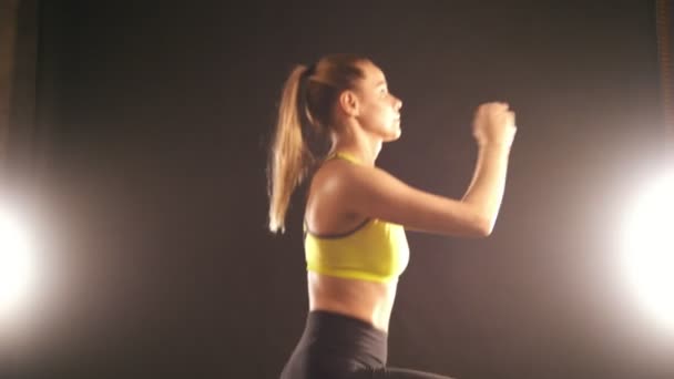 Гнучка жінка в студії робить присідання вправи для сідниць — стокове відео