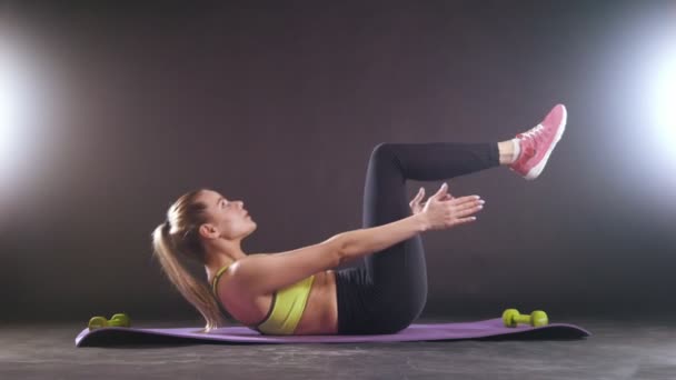 Pratiquer le fitness. Belle femme en tenue de sport entraînement musculation en studio — Video