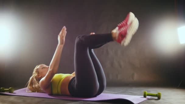 Mujer deportiva en el entrenamiento de ropa deportiva para el abdomen - levanta las piernas — Vídeos de Stock