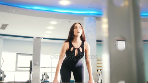 Μαύρα μαλλιά γυναίκα άσκησης στο γυμναστήριο - ανελκυστήρες μέχρι το βάρος, κοντινό πλάνο — Αρχείο Βίντεο