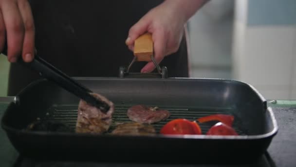 Chef op keuken is het bakken van vlees en groenten in een pan — Stockvideo