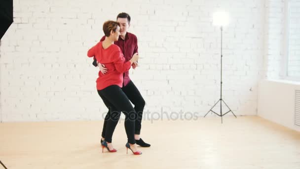 Pareja familiar - hombre y mujer bailando kizomba en estudio blanco cerca de la ventana — Vídeo de stock