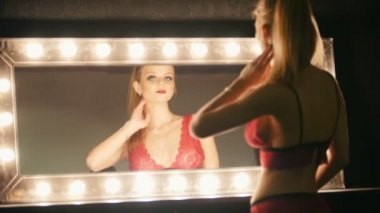 Sarışın genç kadın ayna at arıyorsunuz - fotoğrafçısına poz kırmızı iç çamaşırı