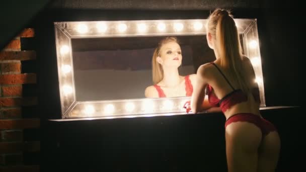 Femme blonde sensuelle en sous-vêtements rouges posant près du miroir — Video