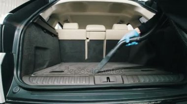Adamın bir elektrikli süpürge ile-lüks araç bagajında gardırop temizlemek araba detaylandırma