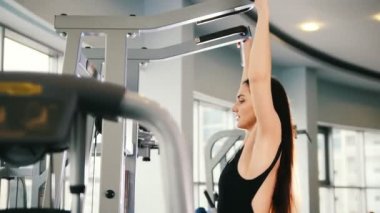 Spor salonunda omuzlar için eğitim - egzersiz çekici genç kadın